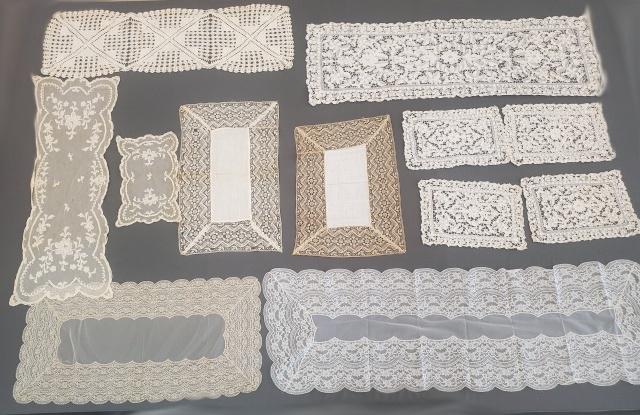 12 Vintage Lace Table Runners and more: 12 vintage table linens including lace runners and a few smaller matching pieces. Included are needle lace, crochet, net lace, and machine lace. In fair to good condition with spots, storage discolora