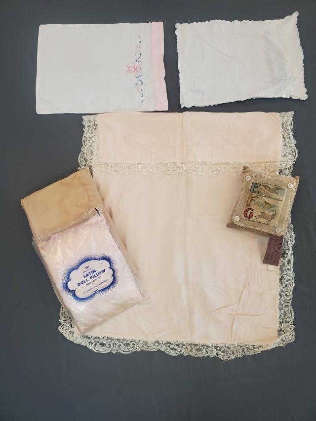 Vintage Baby Linen Grouping: Vintage Baby Linen Grouping with a baby pillow sham, baby pillow case, 2 baby pillow, one still in packaging, and a pillow with a reprinted alphabet page from a 1900 book, probably newly made. And a s