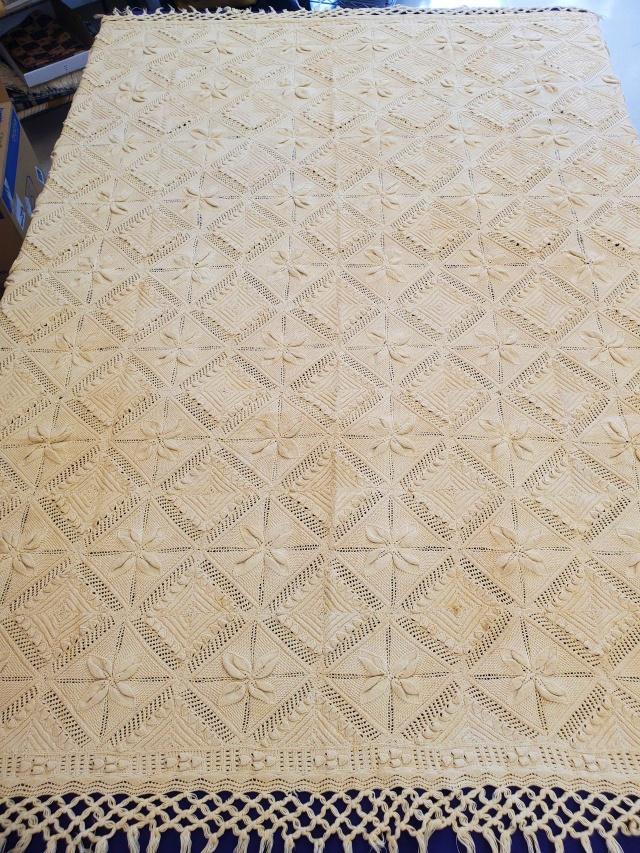 Vintage Ecru Knit Blanket with Fringe: Vintage ecru cotton knit blanket measuring 72x83 inches with 5 inch fringe along 4 sides. Blanket is filled with dimensional 4 petal flowers and alternating diamond motifs. In good condition with a fe