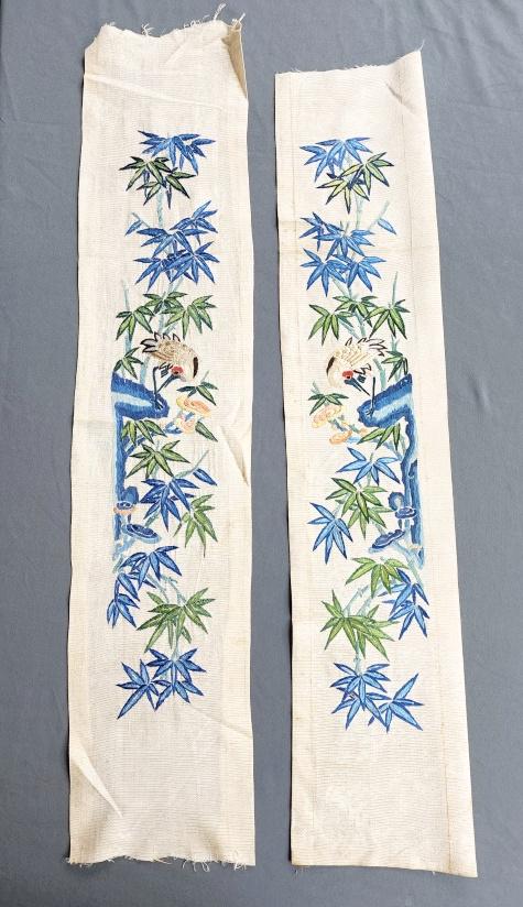Pair of Chinese Embroidered Silk Sleeve Bands - Cranes: Pair of antique Chinese sleeve bands, ivory silk with embroidery and couched metallic threads depicting bamboo and a crane. Measures approximately 5.5 x 27 inches each. In fair condition with spots an