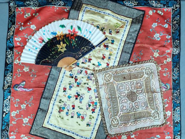 Group of Asian Textiles & Fan: Includes a small, silk, hand embroidered table cover measuring approximately 29.5 x 30.5 inches, red silk with hand embroidered flowers and butterflies with a blue silk backing, in poor condition with