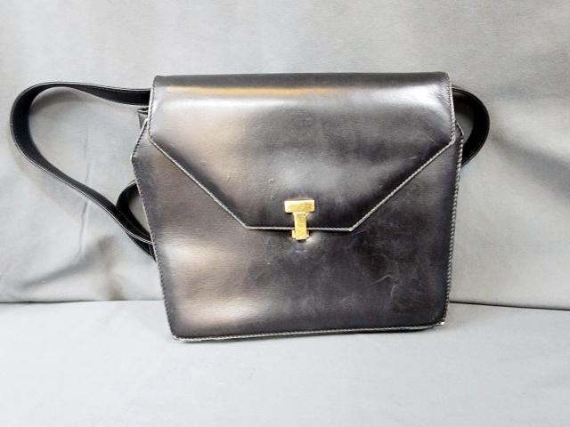 Tiffany Black Leather Purse - T Clasp: Tiffany and Company black leather hand bag with a golf tone T clasp. Long leather shoulder strap. Marked Tiffany & Co on the tag inside. In good condition with minor scuffs. Purse measures 9.5x7x2.5 i