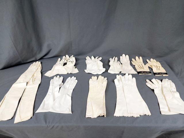 9 Pairs of Vintage Ladies White Gloves: 9 Pairs of vintage ladies white gloves in fabric and leather. Includes 1 pair of opera length, Kid Leather, made in Italy, 6.5, has spots and missing button. White cotton appears to be hand made, no m
