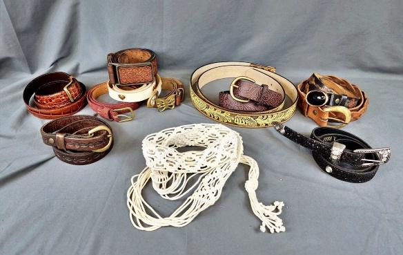 Group of Vintage Ladies Belts: Group of vintage ladies belts including macrame, tooled leather, cowhide, and more. A few solid brass buckles like the butterfly. The yellow tooled leather has no buckle. In good to very good conditio