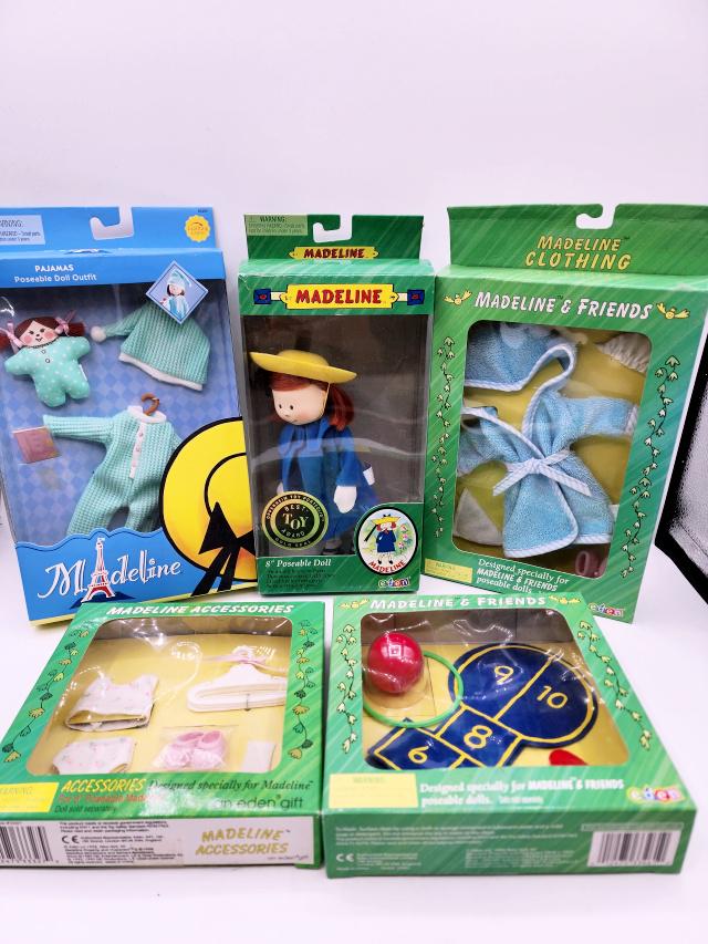 Madeline Doll by Eden with Clothing - In Boxes: Group includes an 8" poseable Madeline Doll by Eden 84100. She has been removed from her box and played with, but appears complete. She has a dark spots on her nose. Along with 4 boxed outfits/accesso