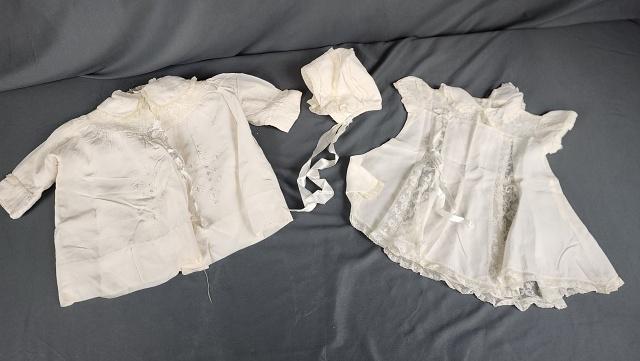Vintage Baby Christening Outfit: Vintage Baby Christening Outfit is a white acetate or other satin feel fabric with embroidery and lace. The outfit includes a dress, jacket and baby bonnet. All in good condition with some yellow spot