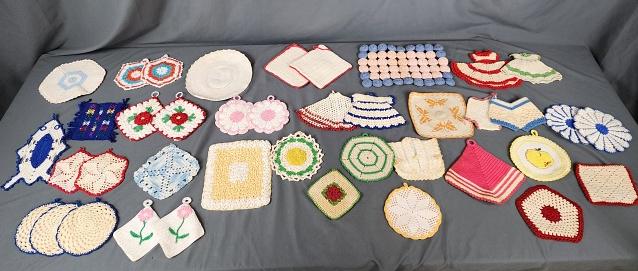 Large Group of Vintage Crocheted Potholders: 40 Vintage Crocheted Potholders. There are potholders and trivets. 7 pairs, one set of three, mostly singles, some flowers, little dresses, bloomers and more. In overall good to very good condition wi