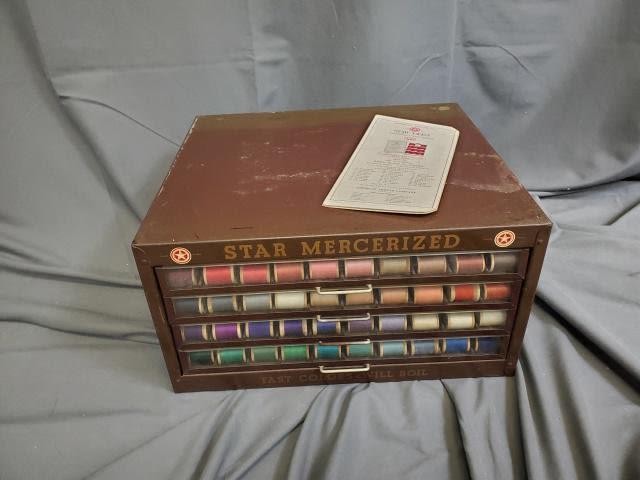 Vintage Star Mercerized Metal Spool Cabinet with Thread: Vintage Star Mercerized Metal Spool Cabinet measuring 16x14x8.5 inches with 4 drawers and 183 wood spools of thread. Also included ins a thread color chart. In fair condition with rusting on the cabin