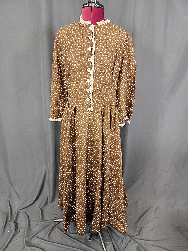 Vintage Brown Country Calico Dress: Vintage Brown Country Calico Dress with long sleeves, eyelet trim on collar, cuffs and down center of bodice. Buttons down the front and a side zipper. Appears to be home made and appears to be cotton