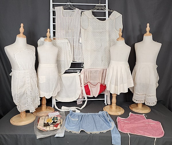 11 Vintage Child Aprons and Pinafores: 11 Antique Child Aprons and Pinafores, along with an apron pattern and scraps. Includes a white cotton half apron with pleats, has spots. A white cotton half apron with bobbin lace, has spots. A small