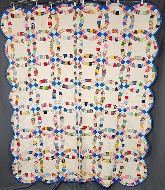 Vintage c1970 Double Wedding Ring Quilt: Vintage c1970 Double Wedding Ring Quilt measuring 73x87''. Comprised of 42 interlocking rings 17'' in diameter, set straight , 6x7. The arch are a variety of 1970's cotton and polyester prints and sol