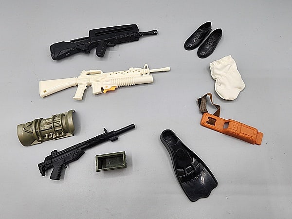 Group of GI Accessories, more: Group of GI Joe and other military action figure accessories. Includes a metal ERTL Famas Assault incomplete. White toy rifle, and a black toy rifle, no markings, and orange holster/case, green box, g