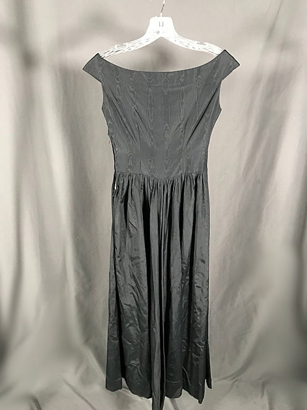 Vintage Ladies Black Moire Dress c1950: Vintage Ladies Black Moire Dress c1950. This cocktail length black moire dress features a classic 50's silhouette, boat neck, and a side metal zip closure. Measurements laying flat: bust 15'', waist 1