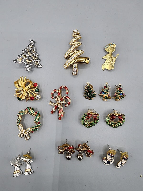 Christmas Jewelry-Monet and More: Large Group of Christmas Jewelry- Monet and More. The group includes 1 textured gold tone and rhinestone Christmas bow brooch measuring 2'' wide by 1.5'' high. Maker unknown and in good condition. 1 m