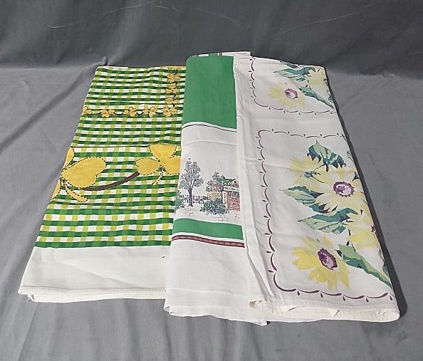 3 Vintage Printed Tablecloths - Yellow and Green: 3 Vintage Printed Tablecloths - Yellow and Green. Group includes gold clover on green plaid, rayon, 47"x 49 1/2", good condition with one stain noted. Green border with village scene, cotton, 61" x 48