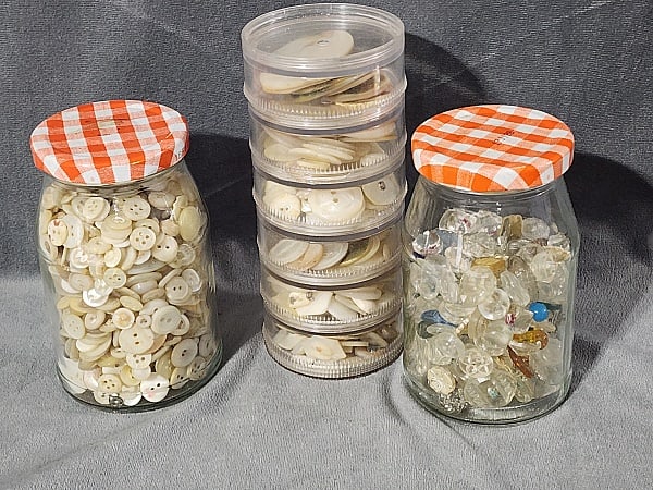 1,100 Vintage and Antique Buttons: Large Group of 1,100 Vintage and Antique Buttons. The group includes 1100 vintage and antique buttons stored in vintage glass jam jars and a circular plastic storage tower with compartments. The butto