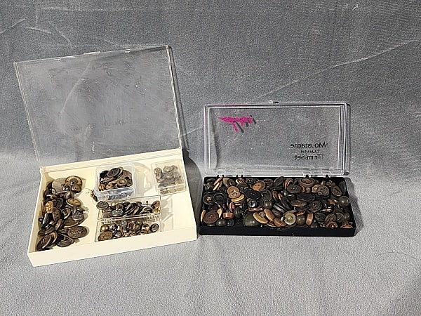 415 Vintage and Antique Buttons: Large Group of 415 Vintage and Antique Buttons. The group includes 415 vintage and antique buttons stored in plastic lidded cases. The buttons are made of glass, shell, vulcanite, early plastic, brass