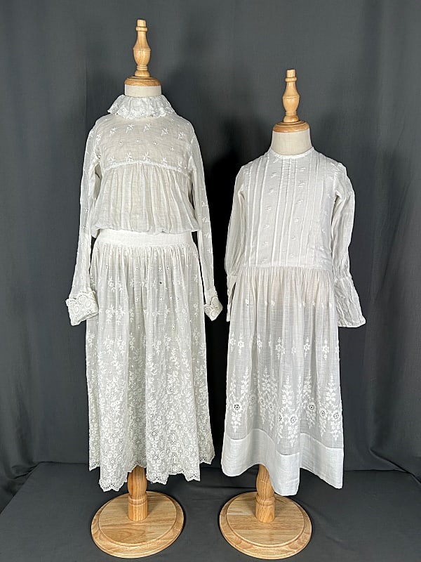 Late 19th Century Childrens Dresses: Late 19th Century Children's Dresses. The lot includes 1 late 19th century childrens white cotton dress featuring long sleeves, pin tucks, hand embroidery, cut work, and mother of pearl buttons down t