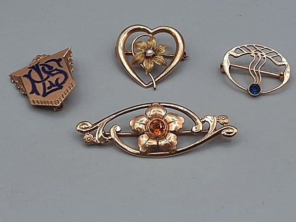 Group of 4 Deco 10K Brooches: Group of 4 Deco 10K Brooches. The lot includes 4, 10K gold deco brooches featuring 1 ovoid floral brooch with scrollwork and floral accents and a 4mm bezel set citrine measuring 1 3/4'' x just over .5