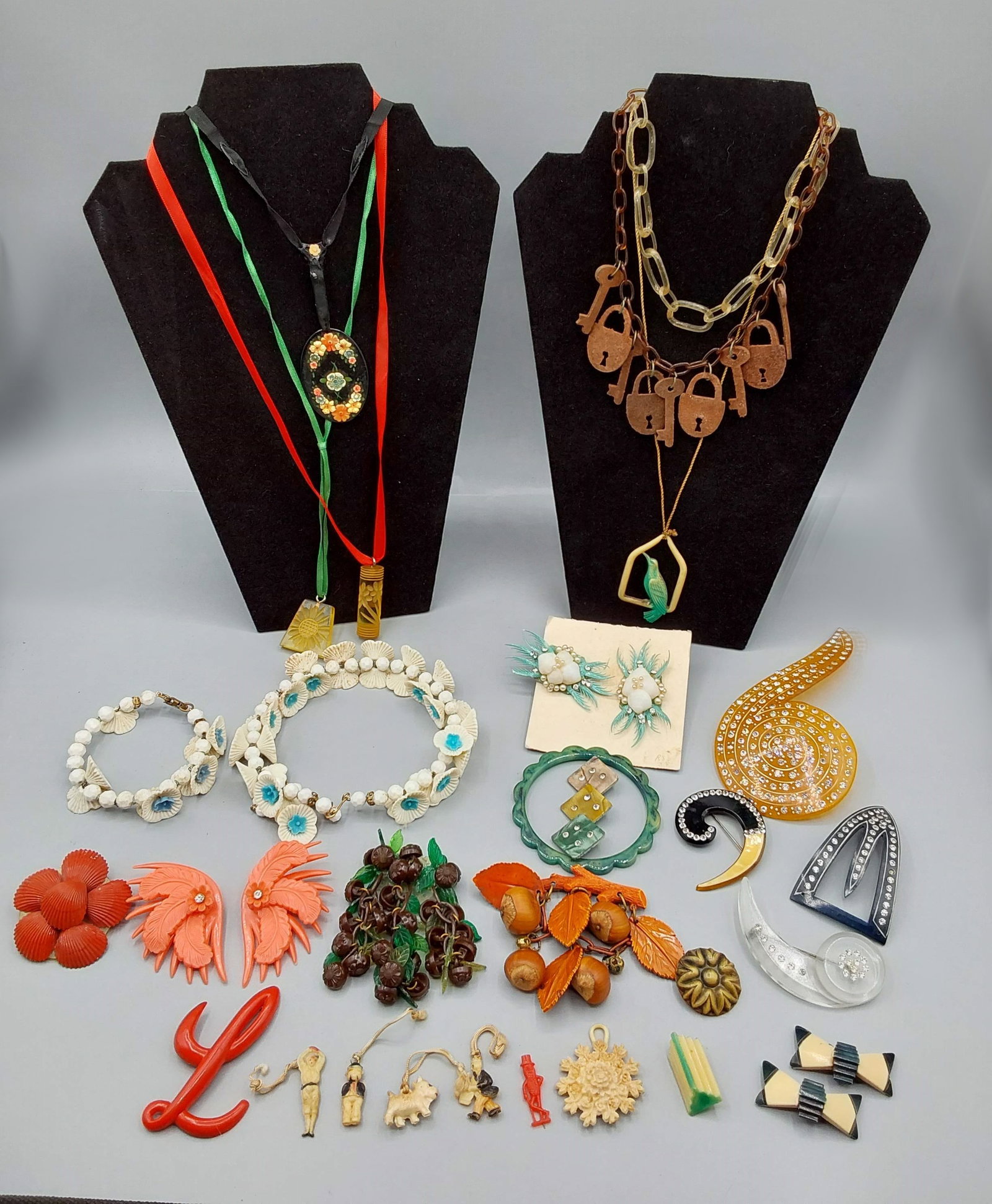 Vintage Plastic and Celluloid Jewelry: Vintage Plastic and Celluloid Jewelry. The lot includes 26 pieces of vintage c1920-1950 celluloid/Lucite/plastic jewelry featuring 2 pairs plastic earrings, 2 necklaces with carved Lucite pendants, 1 