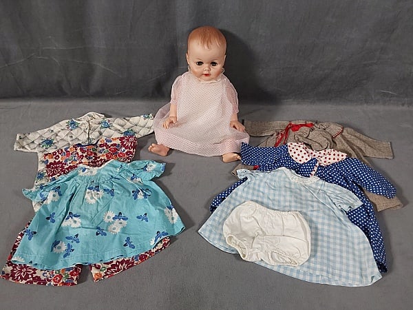 Vintage 18 inch c1950s Drink and Wet doll: 18" c1950s drink/wet doll wearing original outfit plus wardrobe. Wardrobe includes coat with bonnet, onesie pajamas, dress, romper and 3 dresses and panties. Doll is in good condition with minor marks