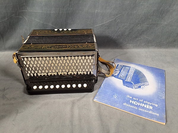 Vintage Hohner Vienna 1-Row Diatonic Accordion: Vintage Hohner Vienna 1-Row Diatonic Accordion. The lot includes 1 vintage Hohner Vienna 1-row, 4-bass, 10 button diatonic accordion in black and gold. It measures (closed) 9'' x 11'' x 6'' and appear