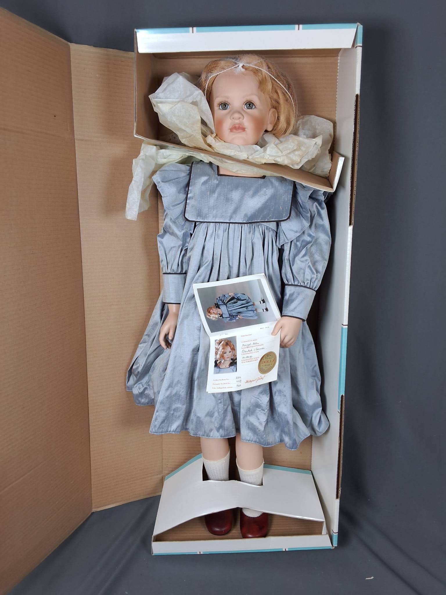 Margot-Helen by Hildegard Gunzel: Standing at 31 inches tall, Margot-Helen is designed by Hildegard Gunzel and crafted by Waltershauser Puppenmanufaktur. She is item #654, doll #449 of 750, and features a PVC head and limbs. Margot-He