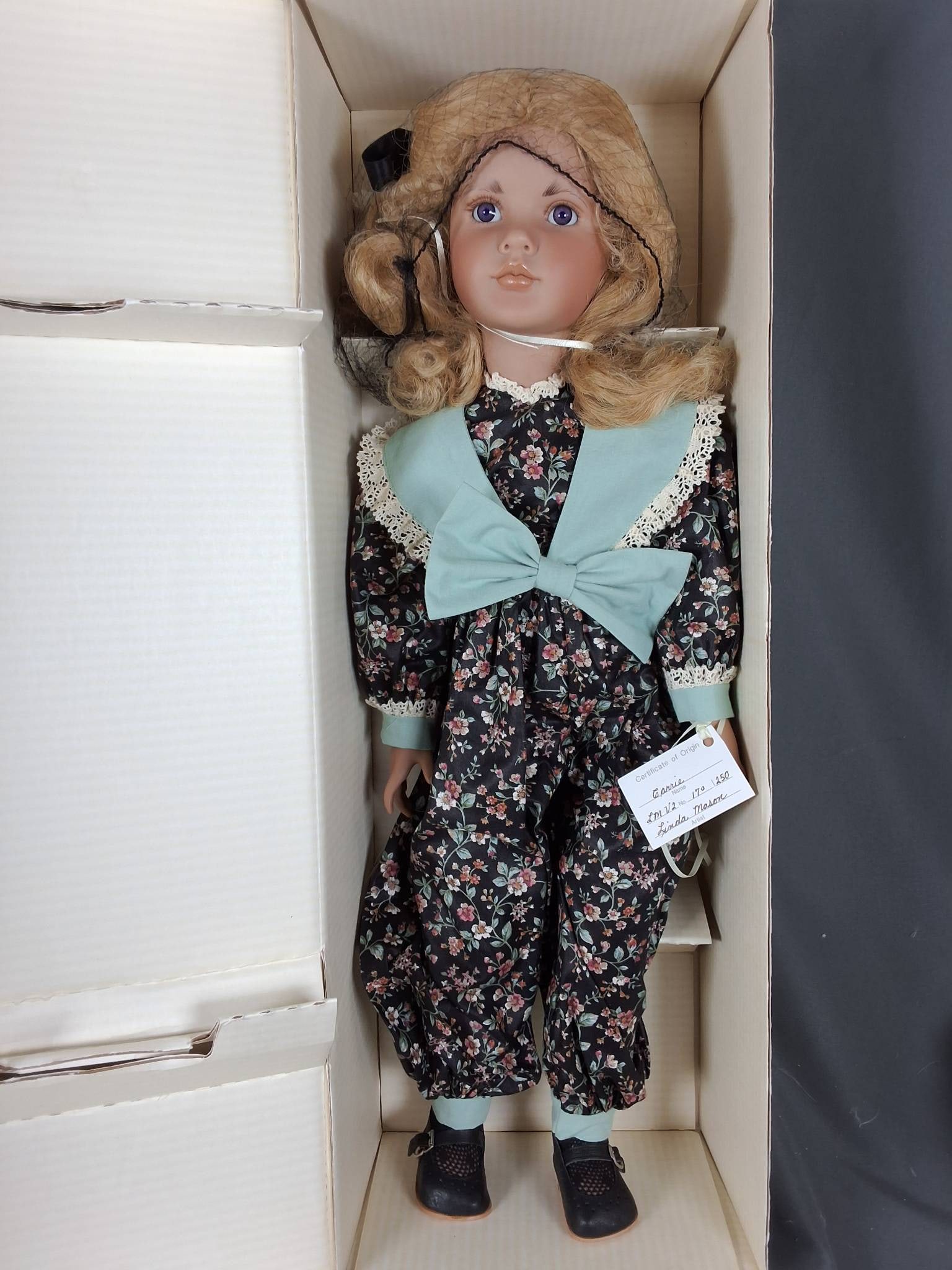 Carrie by Linda Mason: Carrie a PVC doll by Linda Mason, distributed by Dollmakers Originals International Inc., stands at an approximate height of 27 inches. She is number 170 out of a limited 250. Carrie is dressed in a f