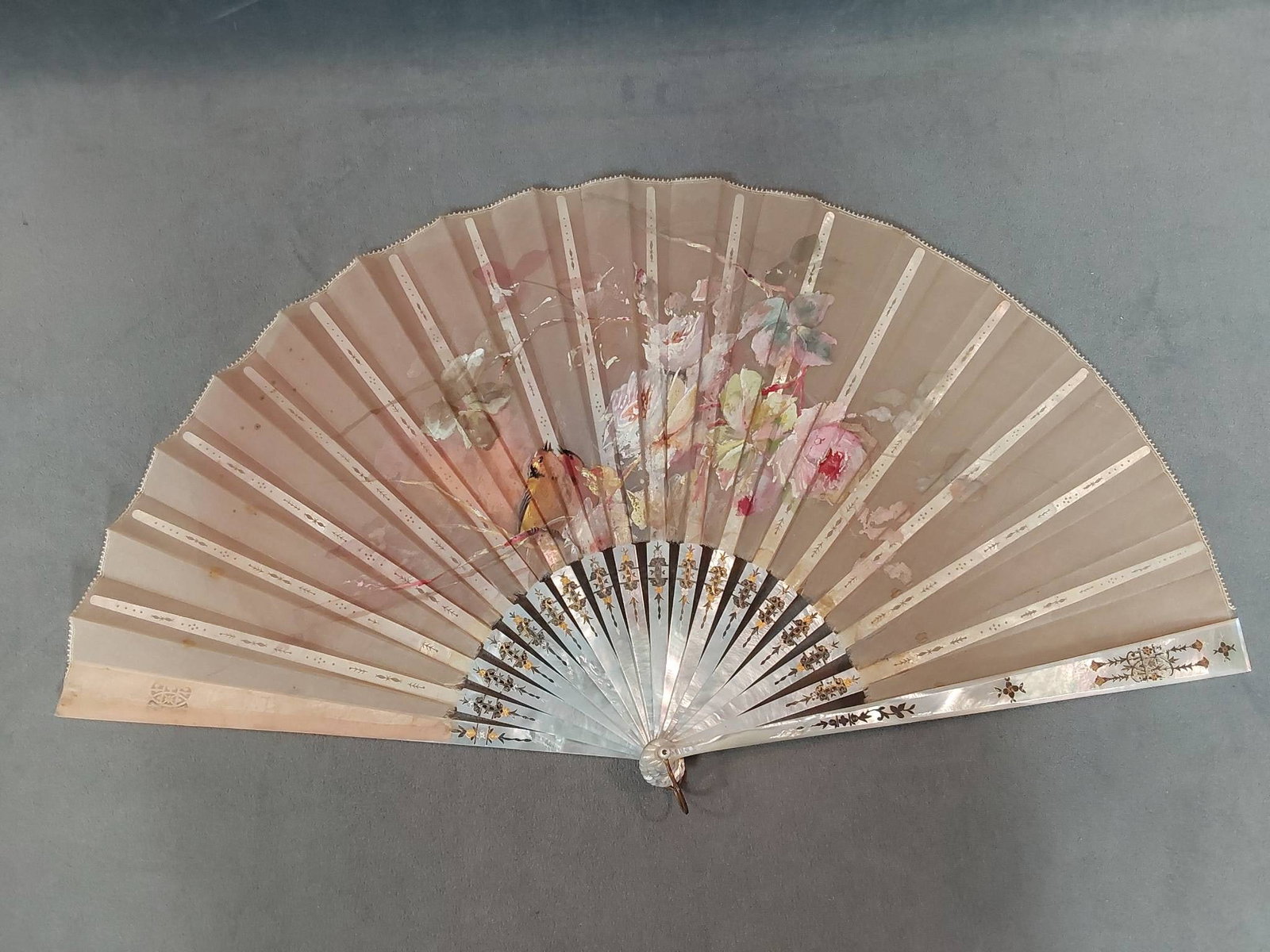 Antique Hand-Painted Silk Folding Fan - Mother of Pearl and Box: Antique folding fan featuring hand-painted sheer silk leaf with floral and bird motifs, and picot trim. Mother of pearl guards and sticks with a mix of hand carved, pierced work, and silver and gold t
