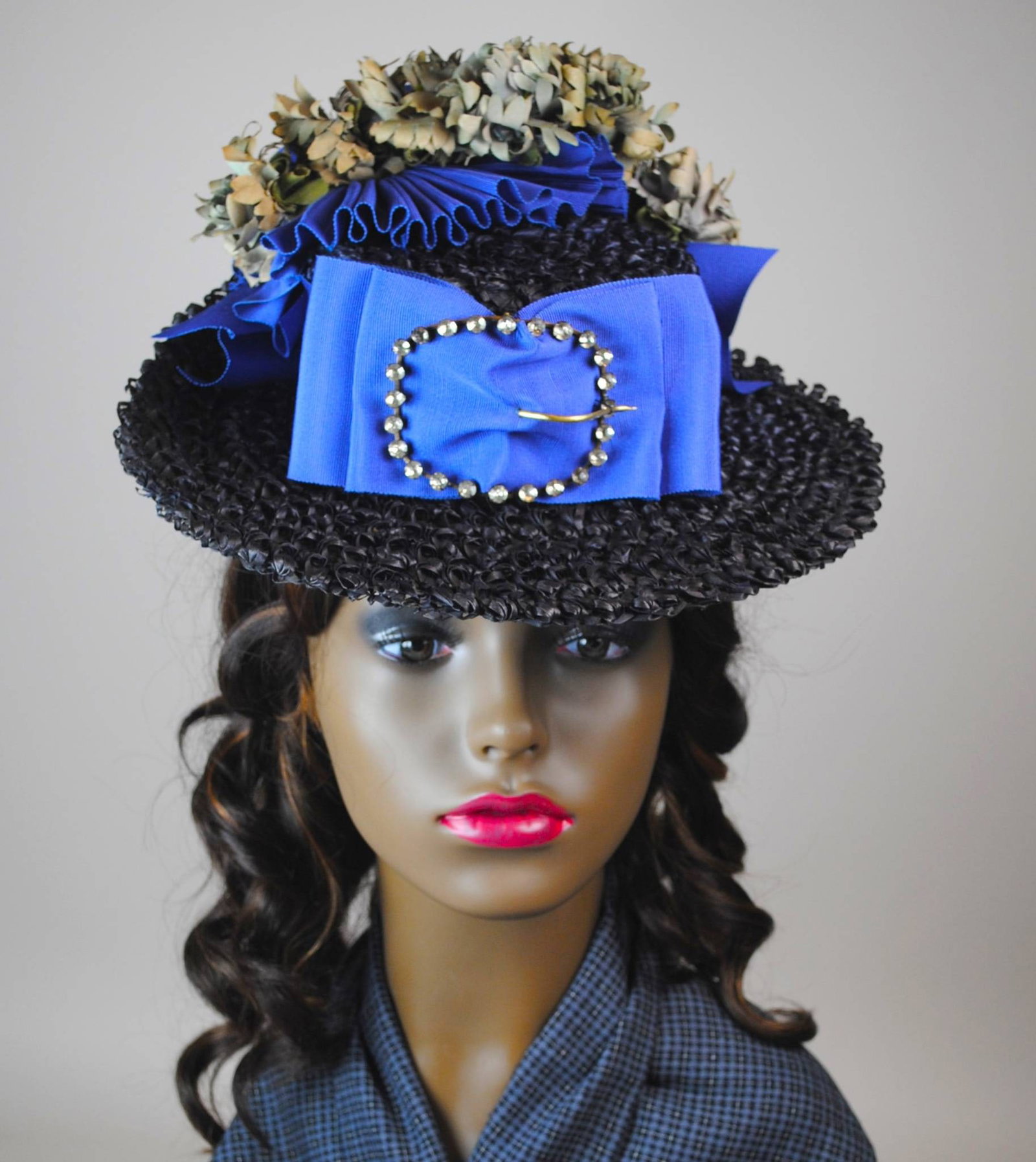 Antique Blue Straw Boater Hat - Large Buckle: Antique navy blue nubby straw boater-style hat adorned with a French Blue grosgrain ribbon. Showcasing a mix of dusty blue-grey flowers and a brass buckle inset with paste stones, the hat offers addit