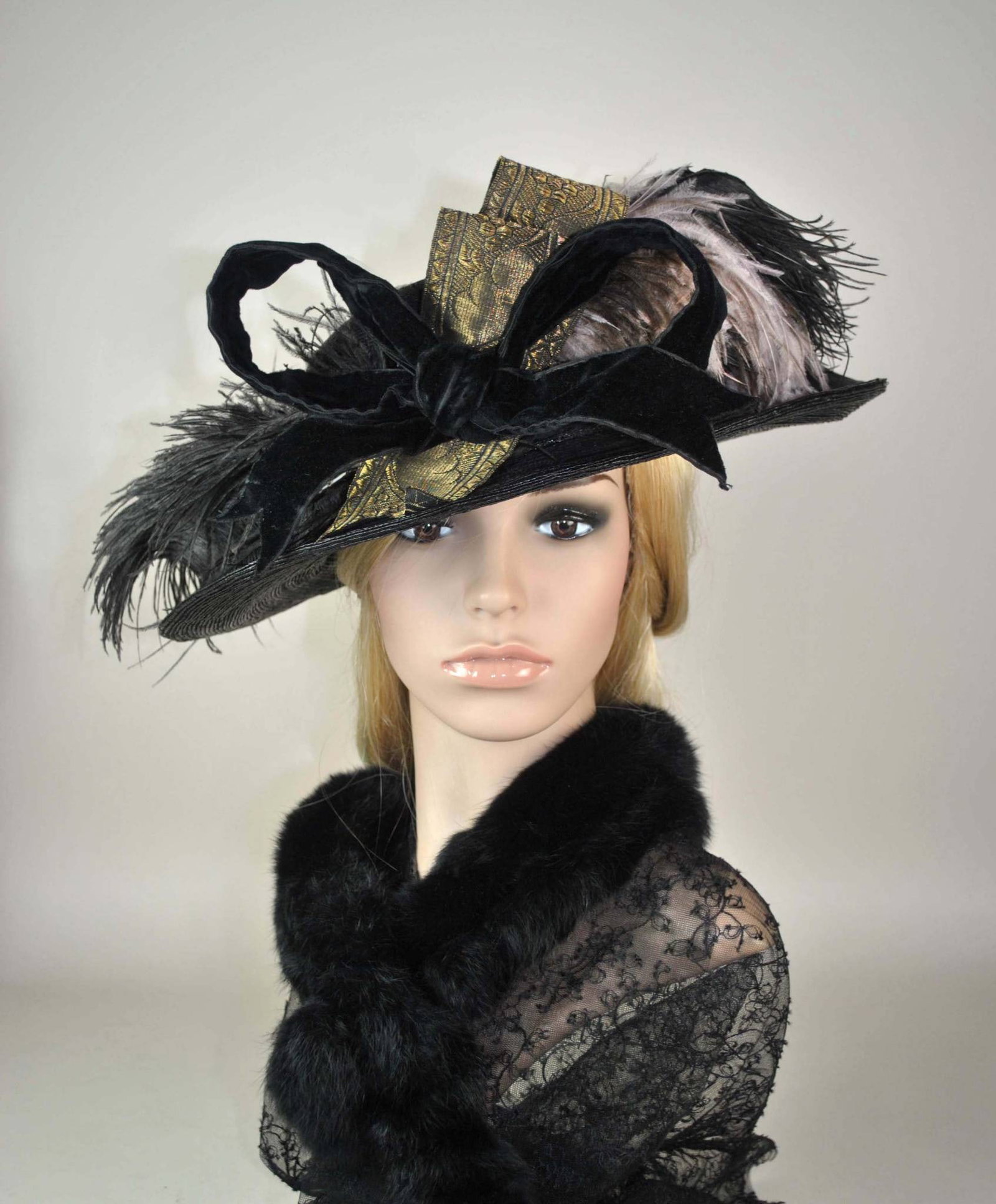 Antique Black Straw Hat by Ufland Millinery Co.: This antique hat features a large-scale black fine straw crown, adorned with a black velvet band and a wired black velvet bow on the front interwoven with gold brocade ribbon. Accentuating the design 