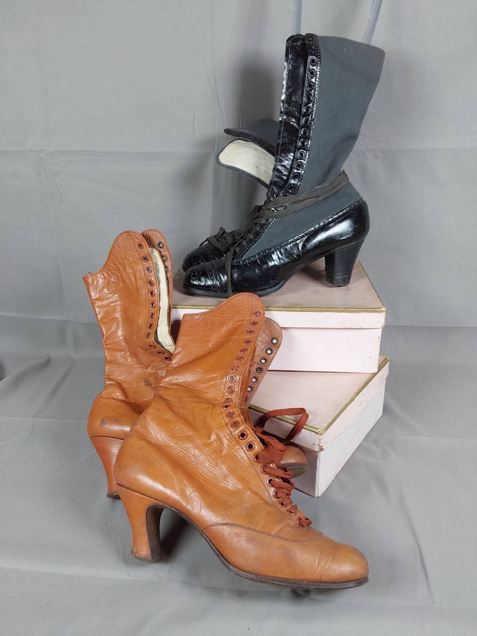 19th Century Ladies Leather Boots: Two pairs of 19th-century ladies lace-up leather boots. The first pair features black leather and grey wool boots by Rondepierre, incorporating Oxford-like details with 23 eyelets on either side, orig