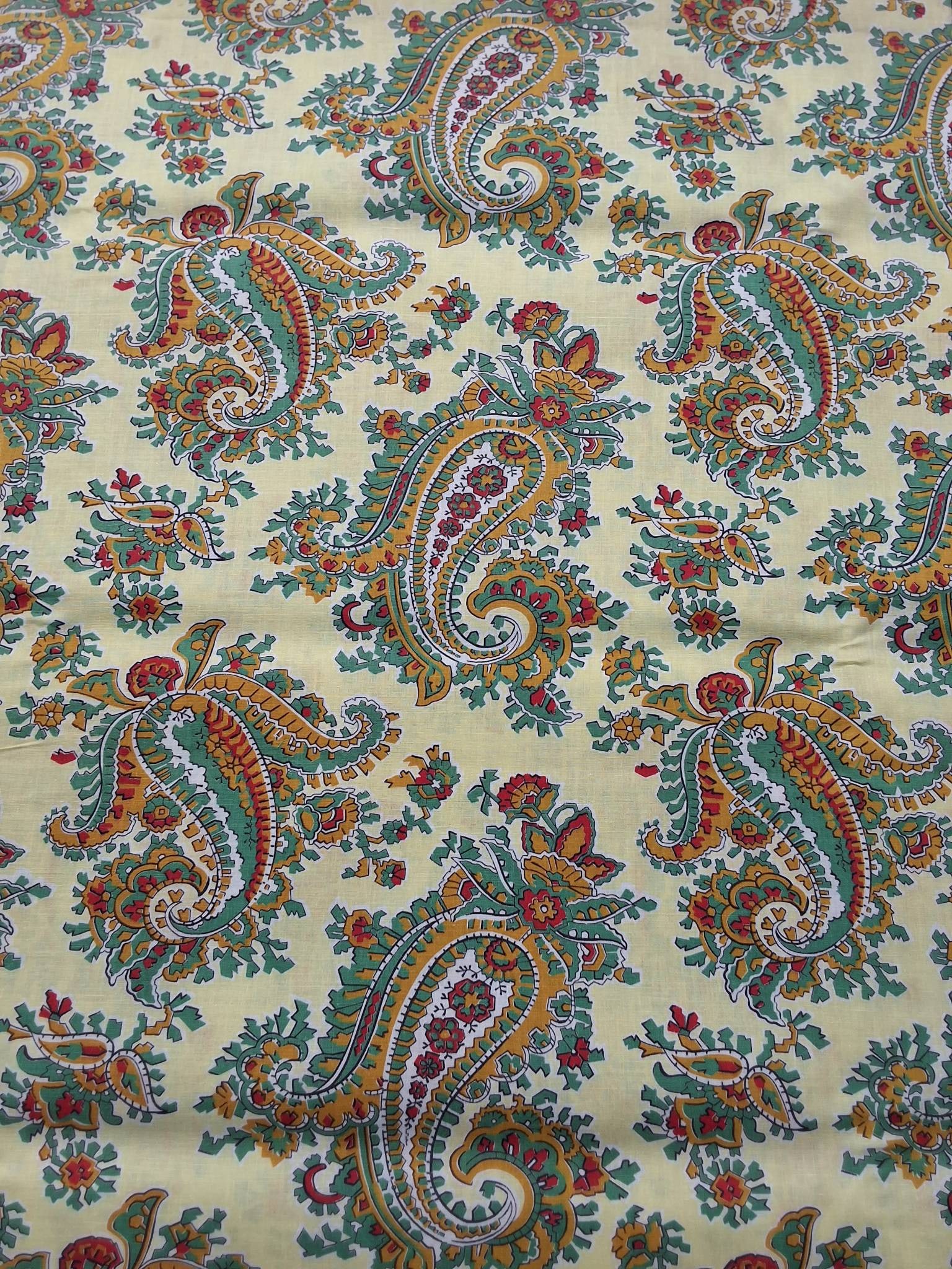 Vintage Fabric - Paisley: Vintage fabric measuring 38inx106in, featuring a pale yellow background with paisley patterns in sage green, gold, and red. The paisleys are both geometric and sinuous, complemented by floral details.