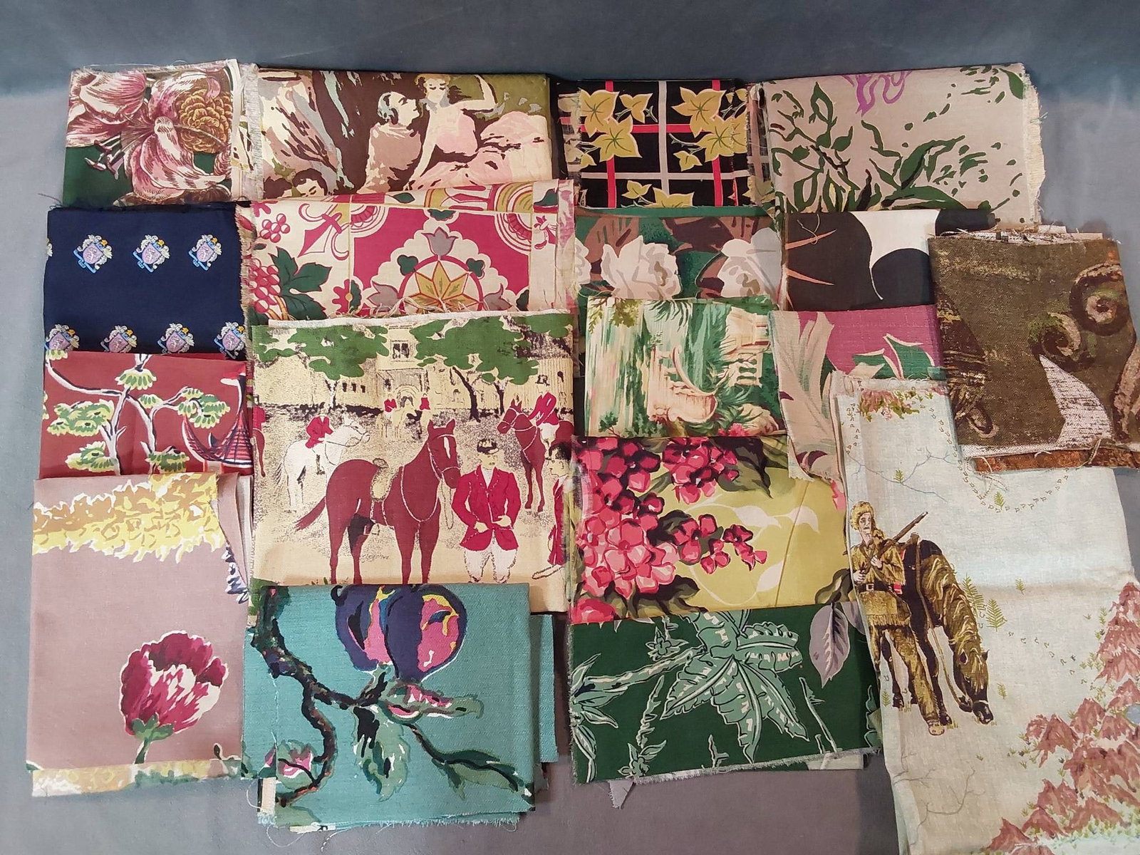 Mixed Lot - Scenic and Florals: A mixed fabric lot featuring various scenic and floral prints. Notable scenes include a young couple beneath a tree, a hunting party, and Davy Crockett. The lot consists of different sizes and pattern