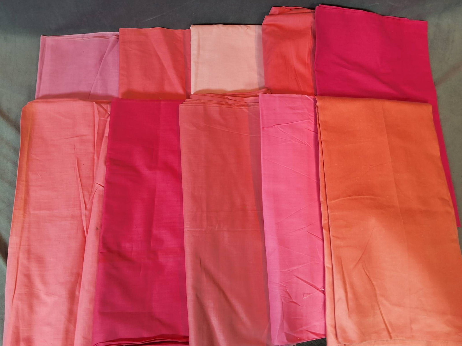 Pink Group C: Vintage cotton fabric lot consisting of 10 pieces of fabric in various shades of pink. The fabric pieces weigh a total of 5lbs and are in good condition, with faint signs of storage discoloration pres