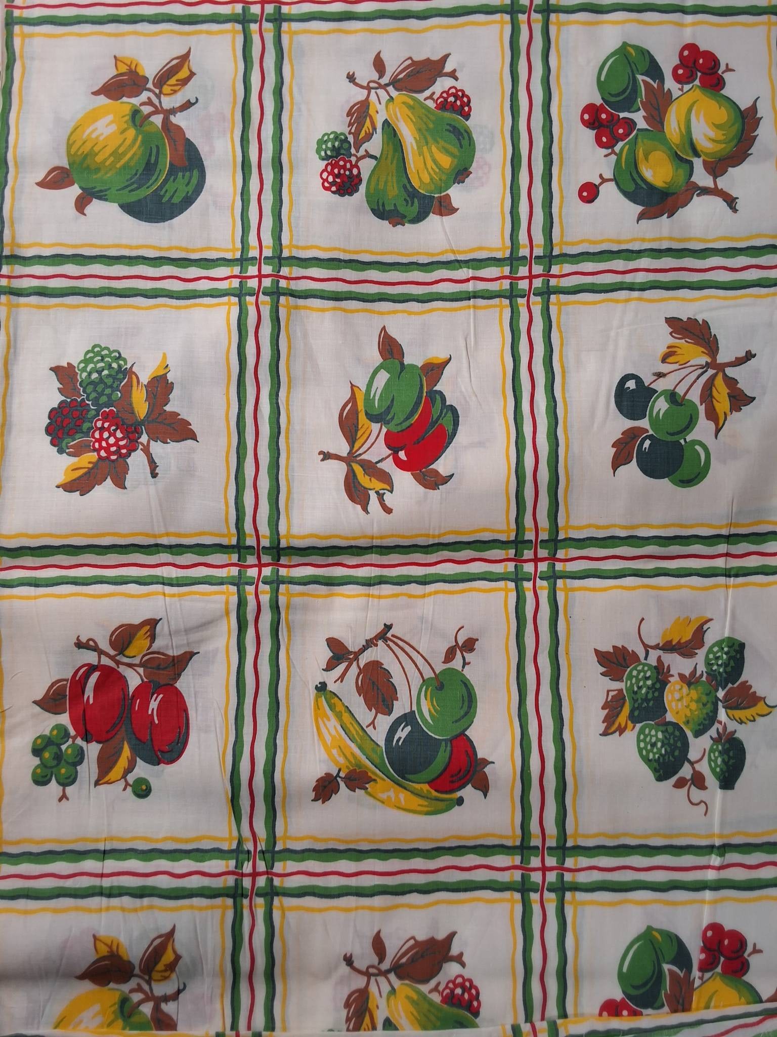 Vintage Cotton Fabric - Fruits: Vintage cotton fabric that measures 34inx407in. It is a patterned fabric featuring cherries, bananas, apples, and other fruit motifs. The design incorporates green, red, yellow, and brown against a wh