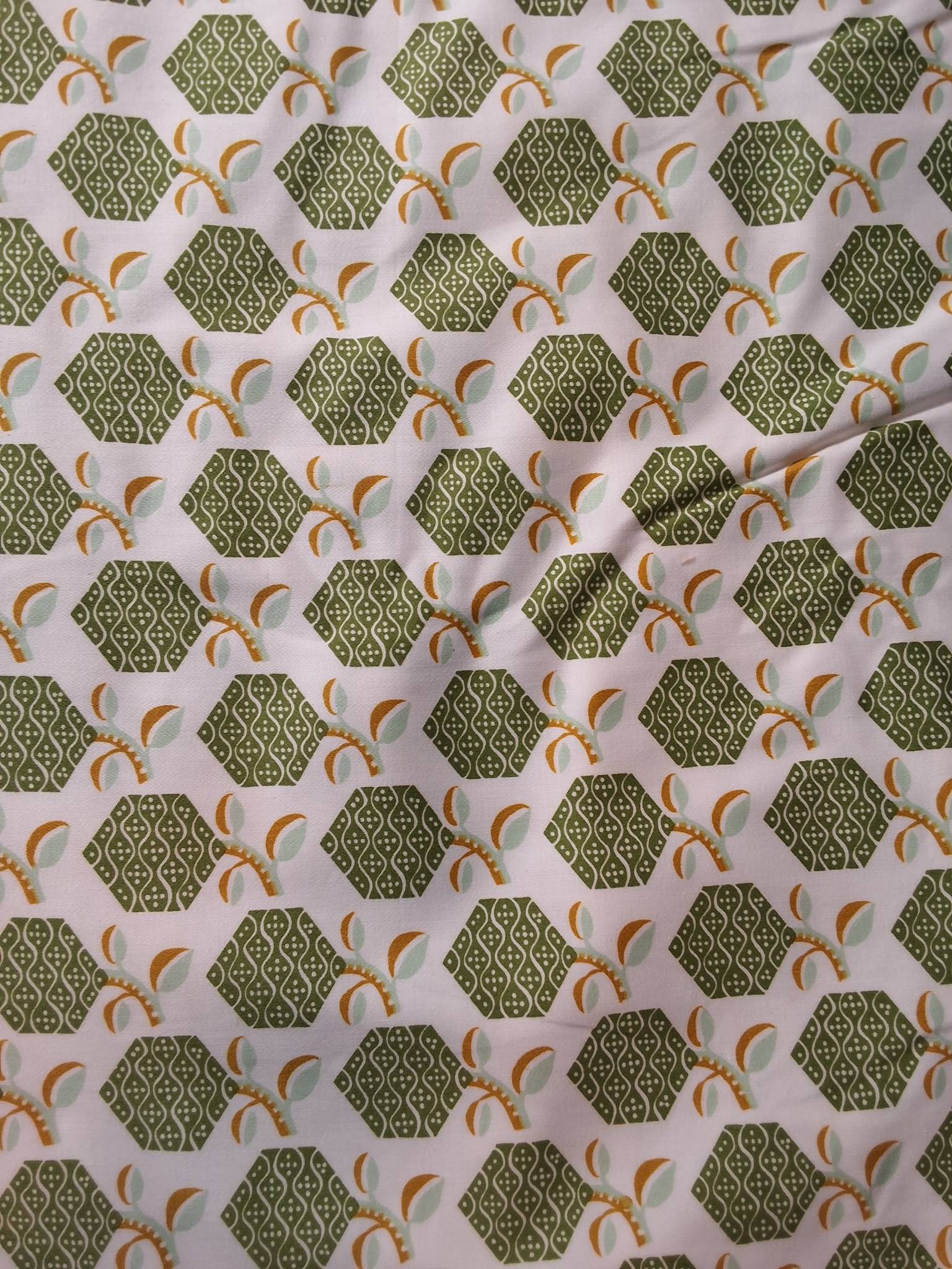 Vintage Cotton Fabric - Green Hexagons: Vintage home decor weight cotton fabric lot measuring 54inx297in. Features a decorative design with green hexagons, curvy lines, and dots. One end includes several leaves attached to a branch. Display