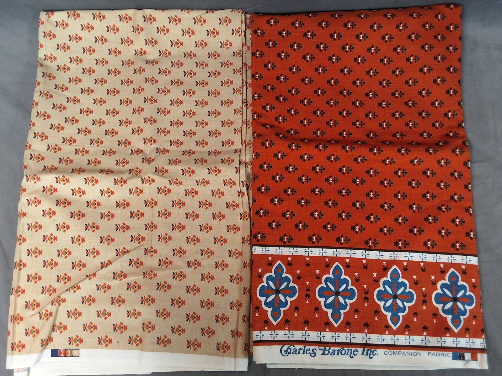 Vintage Cotton Fabric - Floral Motifs: Vintage cotton home decor fabric lot including two pieces. One piece, from Charles Barone Inc., features abstract floral motifs with border patterns in orange, white, blue, and brown. Measures 54inx11