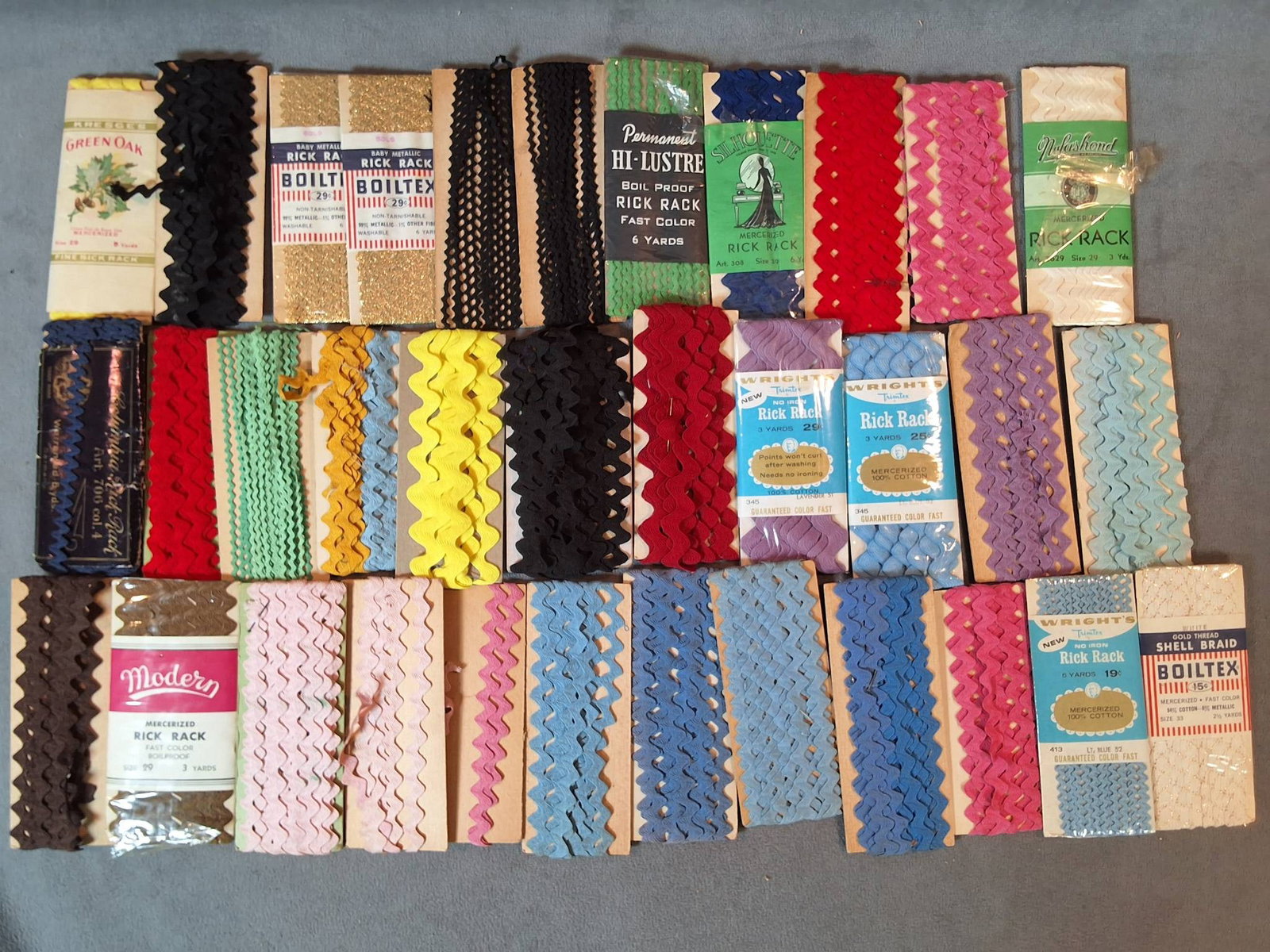 Collection of Vintage Rick Racks: A collection of vintage rick racks in varying designs and colors, made from materials including mercerized cotton, rayon, acetate, and metallic. The collection features solid tones like black, white, 