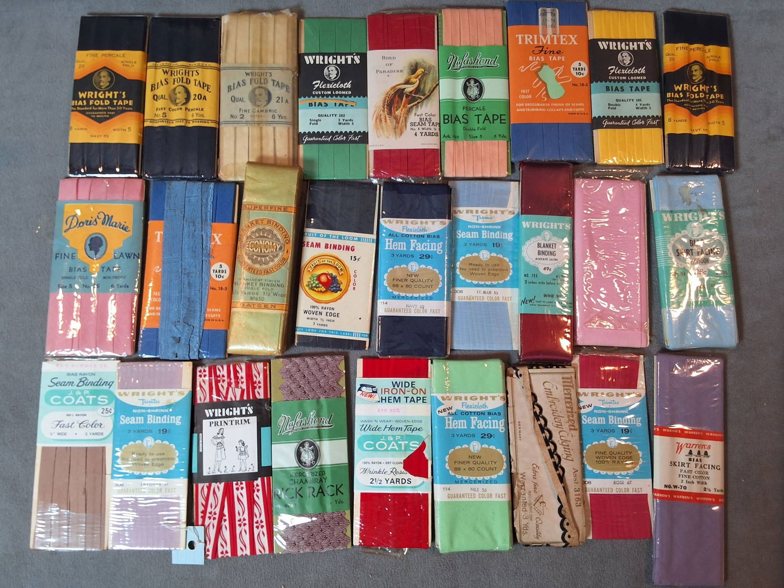 Collection of Seam Bindings and Twill Tape: A collection of seam bindings and a woven twill tape, originating from c1860 or earlier. The seam bindings come in a variety of colors including blue, brown, black, red, green, pink, and others, made