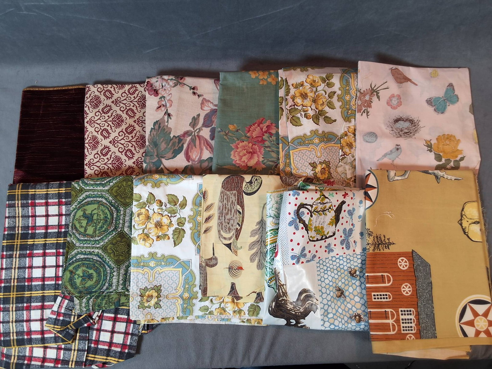 Cotton Fabric - Varied Patterns: Lot consists of 12 pieces of cotton fabric featuring diverse patterns, including plaids, florals, geometrics, and novelty prints. The fabrics showcase a variety of colors including purple, orange, blu