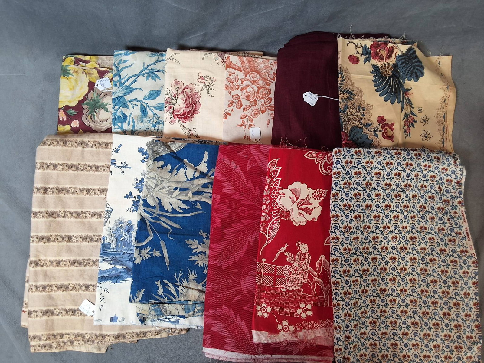 Vintage Cotton Fabric - Assorted Prints: Vintage cotton fabric lot featuring an assortment of florals, stripes, solids, and column designs. The selection includes shades of blue, red, purple, and pink. While the majority of the pieces are in