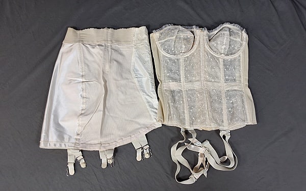 2 Vintage Girdles - Warner Merry Widow: Two Vintage Girdles. The lot consists of two vintage girdles. Featured are two white vintage girdles with the appropriately attached fasteners. From Warner under Merry Widow is a lace longline bustier