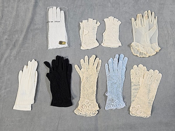 9 Pairs of Sheer Vintage Gloves: Nine Pairs of Sheer Vintage Gloves. The lot consists of nine pairs of sheer vintage gloves. Featured are nine sheer vintage gloves in blue, black, and white. The gloves are all wrist length and they a