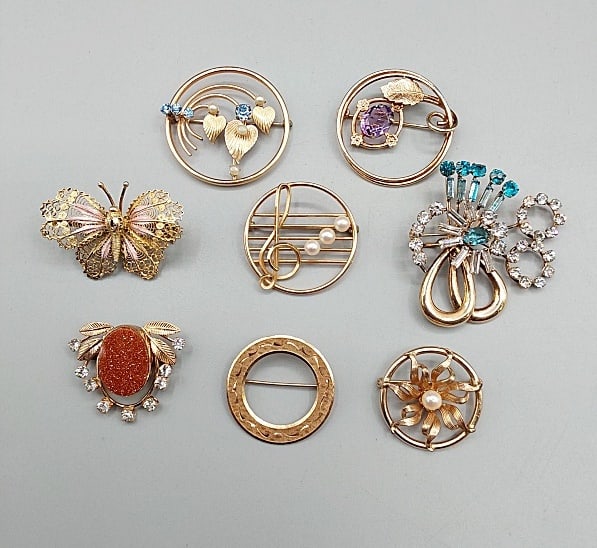 Vintage Gold/Plated Filled Brooches and More: Vintage Gold/Plated Filled Brooches and More. The lot includes a mix of 7 vintage gold filled and gold plated brooches and more. Featuring a 1.23'' 14K gold plated circular brooch by Krementz depictin
