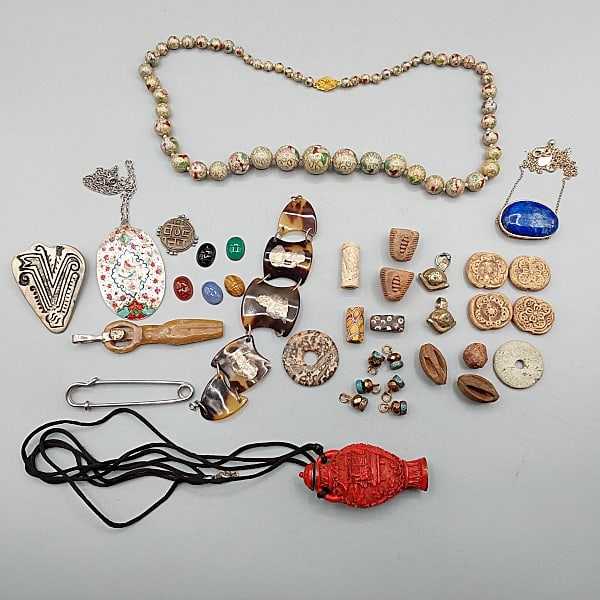 Group of Vintage Ethnic Jewelry: Group of Vintage Ethnic Jewelry. Includes a carved cinnabr lacquer Chinese snuff bottle on a black cord; a 20" gold tone chain with a 1.5" blue lapis stone attached to chain, signed; a 24" single stra