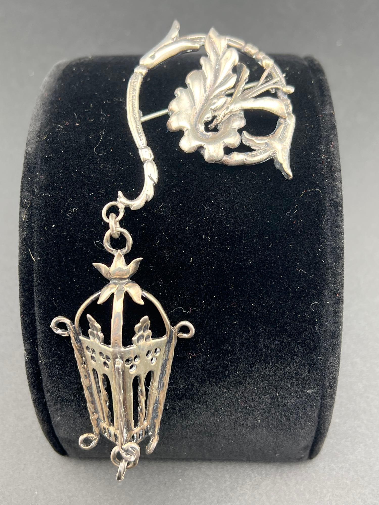 Sterling Brooch W/ Lantern Shaped Pendant: Sterling brooch with a leaf and flowering branch that holds as a pendant a basket or lantern. Total length is 5 inches and total weight is 28.55 grams.If you have any doubt, please ask questions! We w
