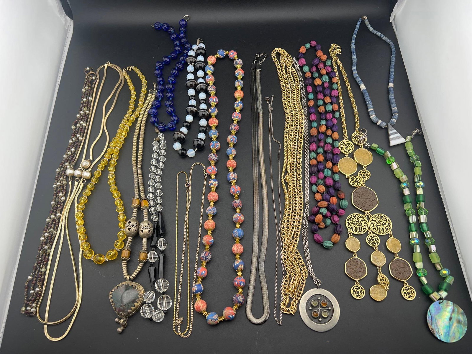 Assorted Necklaces: Grouping of eighteen necklaces to include blue and yellow glass, garnet, crystal, stone, Nine West, R. Tennesmed and more.If you have any doubt, please ask questions! We will provide extra pictures, o