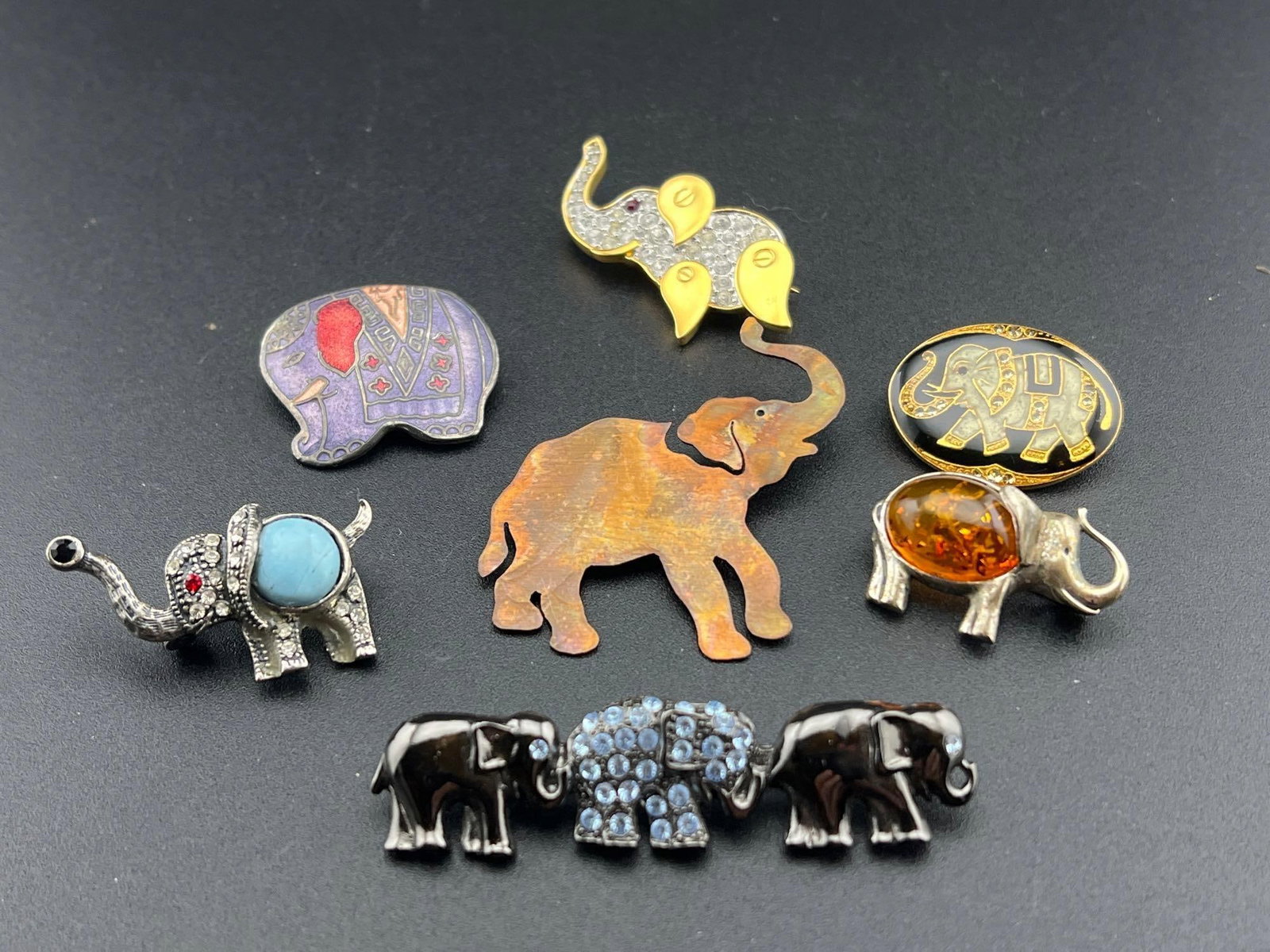 7 Elephant Brooches: Seven elephant brooches, mostly costume, one is unmarked silver & amber.If you have any doubt, please ask questions! We will provide extra pictures, or can schedule an in person or video conference pr