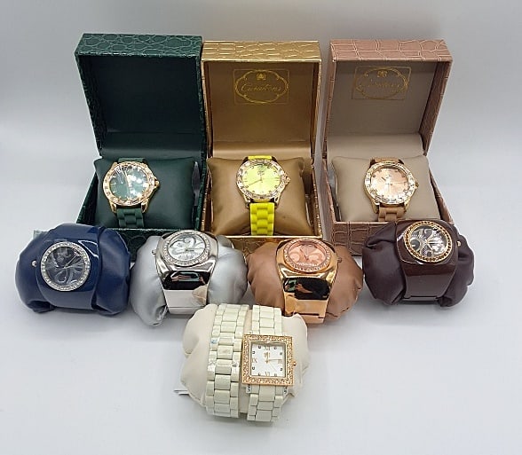 8 Curations Watches: Lot to include 8 watches by Curations: Four of the watches are a bangle style watch with a rhinestone decorated face, 1 watch has a square rhinestone designed face and a white watch band with an addit